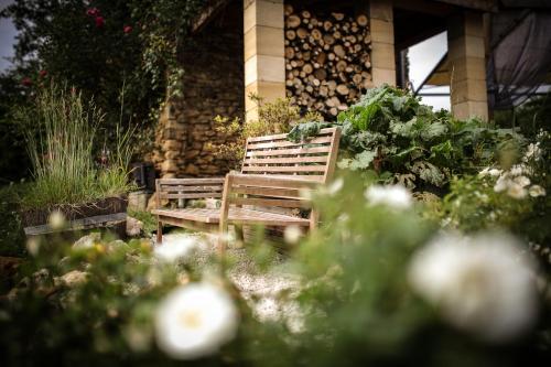 a wooden bench sitting in the middle of a garden at lO GORISSADO - La ferme du glandier in Saint-André-dʼAllas
