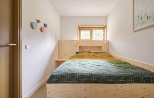 a small bedroom with a wooden bed and a window at 3 Bedroom Awesome Home In Spier in Spier