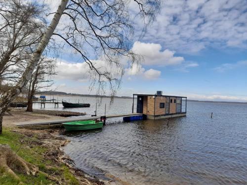 a small house on a dock in a body of water at Hausboot Am See Robert Döring in Riether Stiege