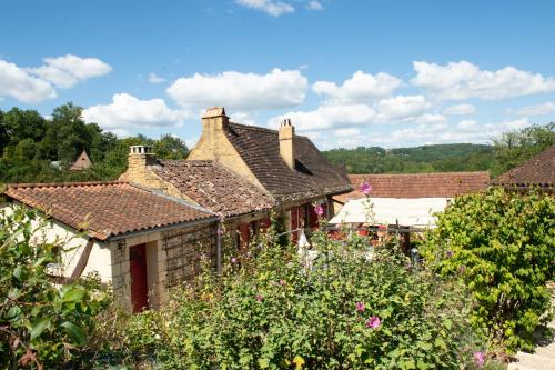 a group of houses with flowers in the foreground at lO GORISSADO - La ferme du glandier in Saint-André-dʼAllas