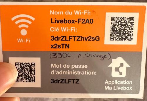 a person holding up a sign with a wifi symbol at Au Myosotis, cosy au pied des pistes avec vue et cœur de station in Les Deux Alpes