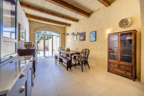a kitchen and dining room with a table and chairs at Lilla Bo - Ocean View Villa in San Lawrenz