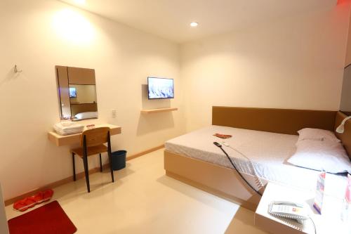 a hospital room with a bed and a sink at Hotel Sogo Dasmariñas Cavite in Dasmariñas