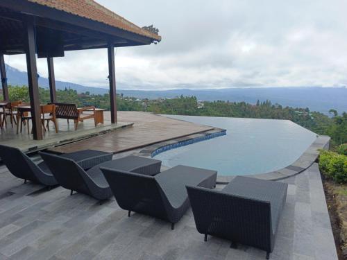 a patio with chairs and a swimming pool at Munduk Tentrem Resort in Munduk