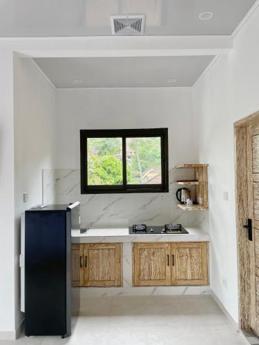a kitchen with a black refrigerator and a window at New Green Coco Villa in Amed