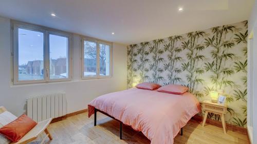 a bedroom with a bed and a wall of wallpaper at Le Brière - Appart'Escale in Saint-Nazaire