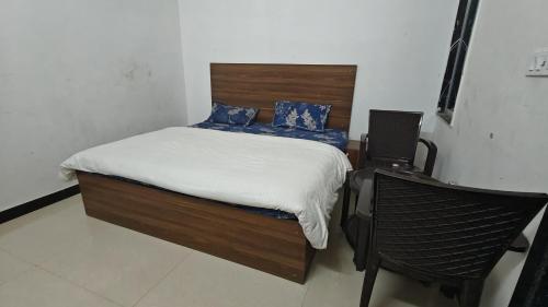 a bedroom with a bed and a chair in it at Ashirwad Hotel And Family Restaurant in Rīngas