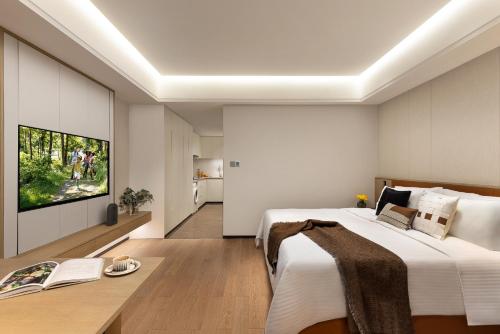 a bedroom with a large bed and a tv at Somerset Wanxia Shenzhen in Shenzhen