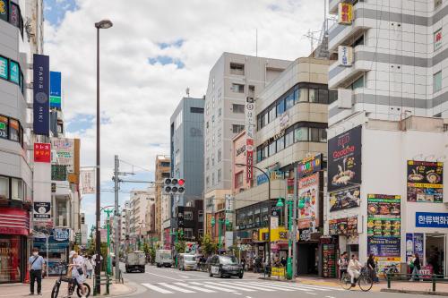 a busy city street with people crossing the street at self-check in-shinjuku-windhouse in Tokyo