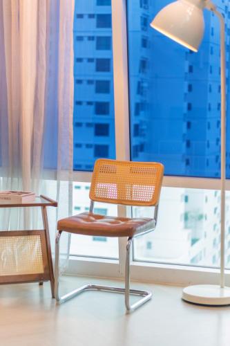 a chair and a table and a lamp in front of a window at Maritime Suites by Stellar ALV in Jelutong