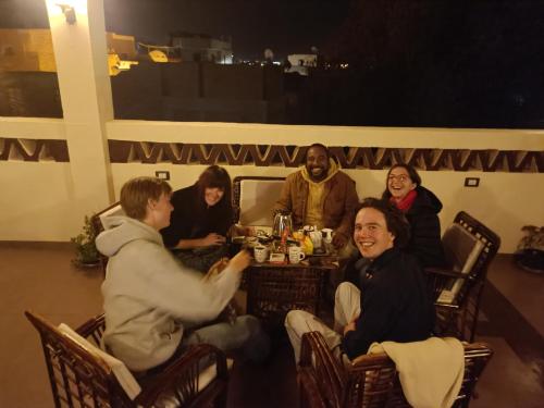 a group of people sitting around a table at Nubian Soul Guest Houses in Aswan