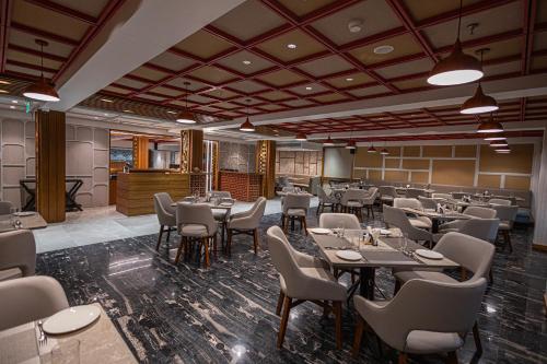 a restaurant with tables and chairs in a room at Ramada Encore by Wyndham Viramgam in Viramgām