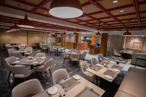 a restaurant with tables and chairs in a room at Ramada Encore by Wyndham Viramgam in Viramgām