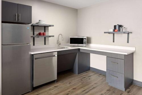 a kitchen with a sink and a refrigerator at Hawthorn Extended Stay by Wyndham Ellsworth Bar Harbor in Ellsworth