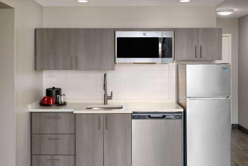 a kitchen with a sink and a refrigerator at Hawthorn Extended Stay by Wyndham Ellsworth Bar Harbor in Ellsworth