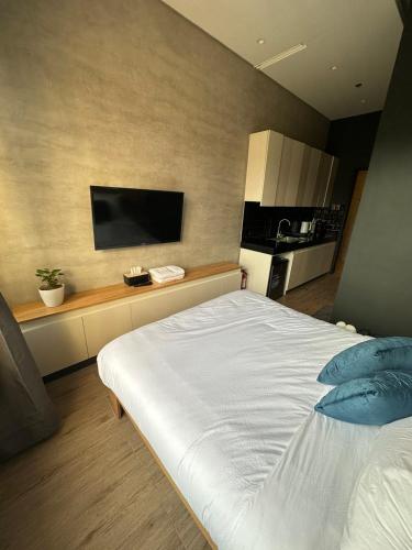 a bedroom with a large bed with a television on the wall at Caldwell Boutique Hotel in Legazpi