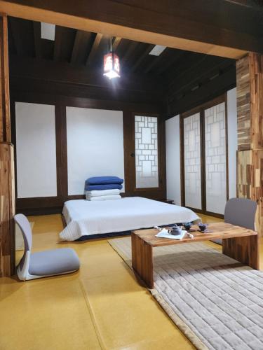 a bedroom with a bed and a table and chairs at HanokInn in Gyeongju