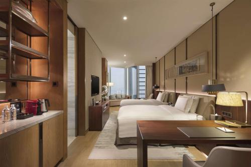 a hotel room with two beds and a desk at Conrad Xiamen in Xiamen