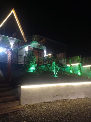 a house lit up at night with green lights at 40 steps Aframe House in Uçgün