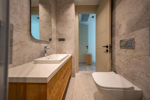 a bathroom with a sink and a toilet and a mirror at Villa with Private Swimming Pool in Bodrum in Bodrum City