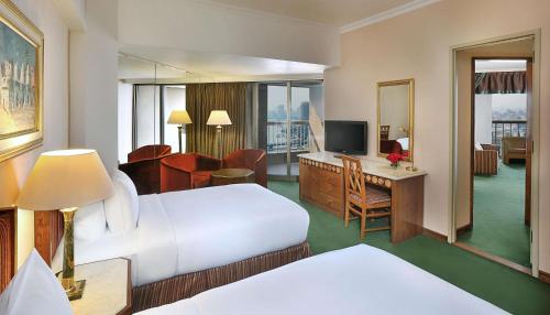 a hotel room with a bed and a desk at Ramses Hilton Hotel & Casino in Cairo