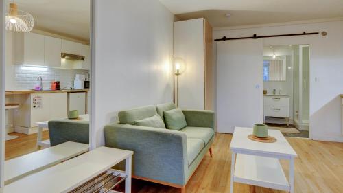 un salon avec un canapé et une table dans l'établissement Le Jade - Appart'Escale, à Saint-Nazaire