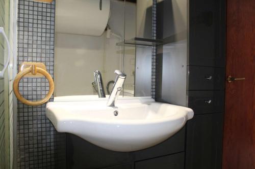 un lavabo blanc dans une salle de bain avec un miroir dans l'établissement Appartement 2 pièces PORT LA NOUVELLE PN590-033, à Port-la-Nouvelle
