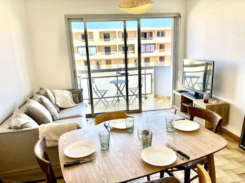 un salon avec une table avec des chaises et un canapé dans l'établissement Appartement 3 pièces Port-la-Nouvelle PN550-012, à Port-la-Nouvelle