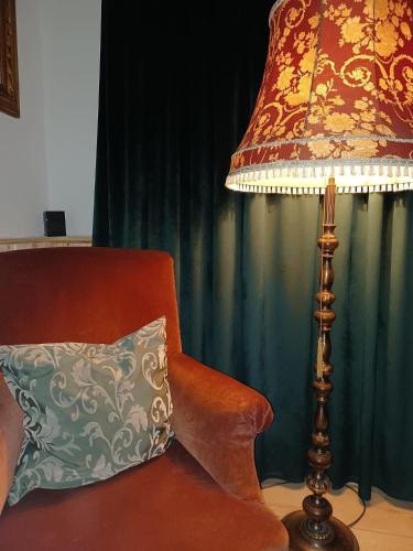 a lamp sitting next to a chair with a pillow at Altes Häusle am Waschbach-Weinberg in Edenkoben