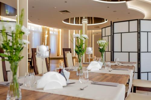 a dining room with tables and chairs with white flowers at Trzy Korony in Głogów Małopolski