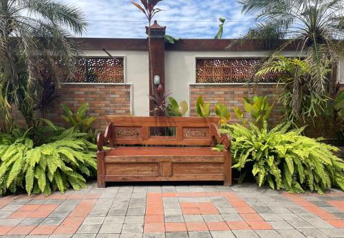 a wooden bench sitting in the middle of a garden at Omah Perengkembang By Secoms in Ngingas