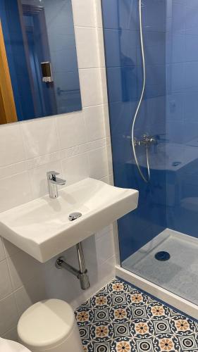 a bathroom with a sink and a toilet and a shower at Pension 23-Vinte e Tres in O Pedrouzo