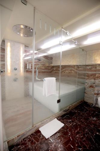 a bathroom with a shower with a glass wall at Bizz The Hotel in Rajkot