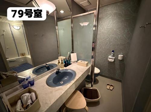 a bathroom with a sink and a toilet and a mirror at 大人専用ホテルイエスタディ in Annaka