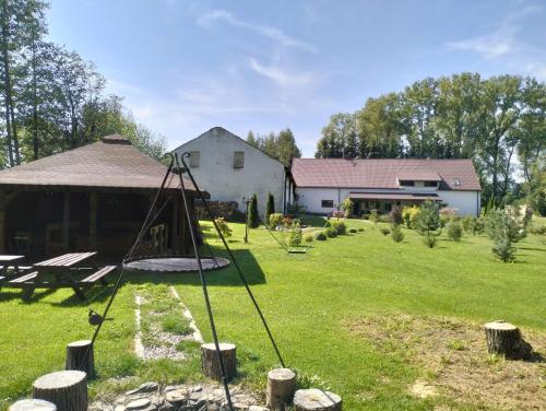 a yard with a swing and a house at Noclegi i sauna w starym domu in Pławnica