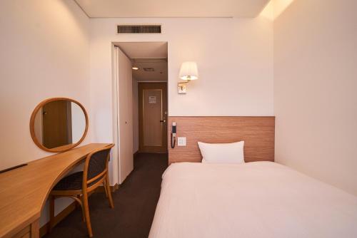 a hotel room with a bed and a mirror at Mito Sannomaru Hotel in Mito