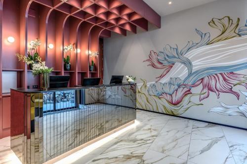 a lobby with a colorful mural on the wall at Madison Hotel in Rome