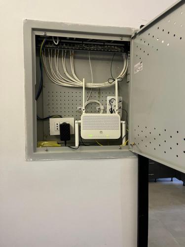 a cabinet filled with cords and appliances at Stylish 2-Bedroom Apartment in Celia Compound, New Administrative Capital in Madīnat al Amal