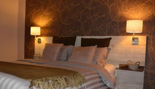 a bedroom with a large bed with two lamps at Couleur Nature, gîte de charme en Ardenne in Stoumont