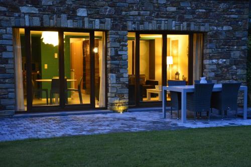 a patio with a table and chairs in front of a building at Couleur Nature, gîte de charme en Ardenne in Stoumont