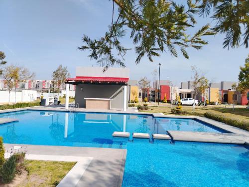 a swimming pool with blue water in front of a building at Exclusiva Casa con Alberca in Bata