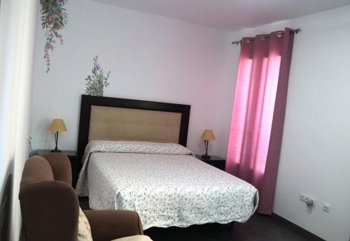 sypialnia z łóżkiem i różowymi zasłonami w obiekcie Casa llena de vida con patio y terraza w mieście Coín