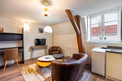 une cuisine et un salon avec une table et des chaises dans l'établissement Le Coquet de Saint-Epvre - En centre-ville, à Nancy