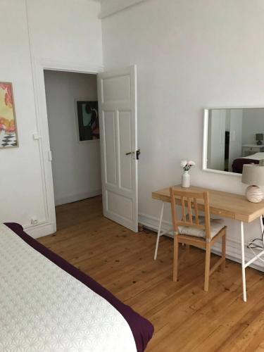 - une chambre avec un bureau, un miroir et un lit dans l'établissement Les 4 chemins, à Vichy