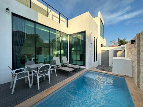une maison avec une piscine, une table et des chaises dans l'établissement CHATEAU DALE POOL VILLA 176 nearby WALKING STREET, à Pattaya (sud)