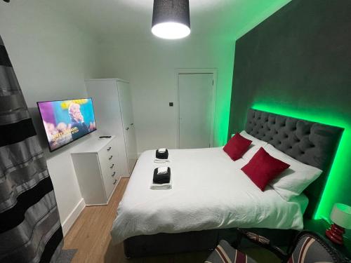 una habitación verde con una cama grande con cabecero verde en Stylish 1 bedroom Flat Brixton, en Londres