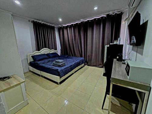 a bedroom with a blue bed in front of a window at Huskies and Company in Pattaya