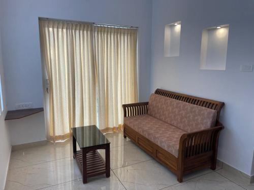 a living room with a couch and a table at RoyalGiri Apartment near Rajagiri Hospital in Alwaye