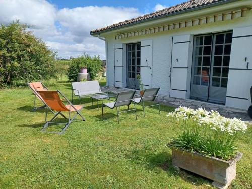 a group of chairs and a table in a yard at Le gîte de l'Ecurie des 3 Châteaux in La Sauve-Majeure