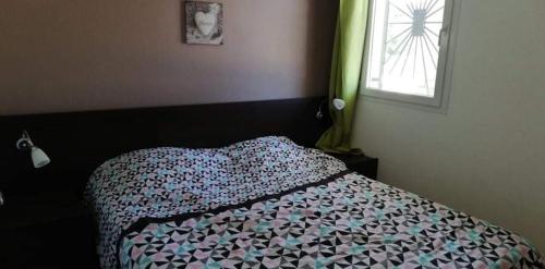 une chambre avec un lit avec une couette et une fenêtre dans l'établissement Appartement T2 bord de mer Corse, à Linguizzetta